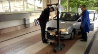 Policjant i diagnosta kontrolują oświetlenie samochodu