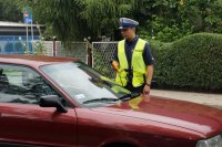 Policjant przystępujący do kontroli trzeźwości kierowcy auta