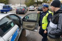 Policjantka z drogówki pokazuje uczniowi radiowóz