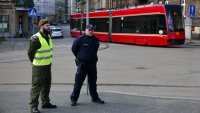 policjant wraz z żołnierzem patroluje dworzec tramwajowy