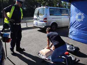 Na zdjęciu kobieta udziela pierwszej pomocy na fantomie pod okiem policjanta.