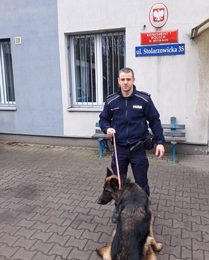policjant z psem przed komisariatem