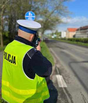 Na zdjęciu policjant dokonujący pomiaru prędkości